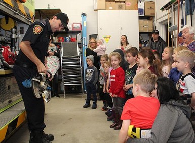 Firefighter Colby Stone shows JEES kindergarten students extrication tools during a tour of the Coaldale fire hall.