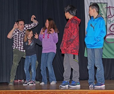 An Evergreen Theatre artist helps Milo Community School students rehearse a scene for the Christmas play.