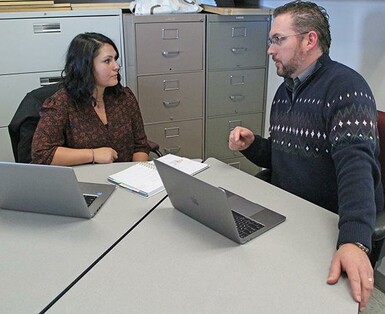 Family Connections worker Katie West discusses a file with teacher Jacob Fraser at Palliser Beyond Borders at Vulcan.