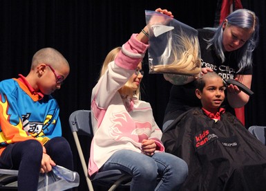 Students and family members had their heads shaved or ponytails clipped to support student Grace Couldwell and Kids Cancer Care.